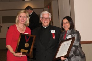 Newman Board of Trustees Chair Linda Davison ’77 presents the Cardinal Newman Medal to Monsignor Hemberger at the Feb. 21 awards banquet.
