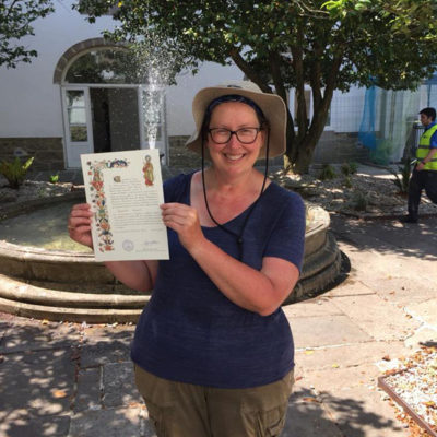 Sarah Evans - holding her Compostela for completing the hike