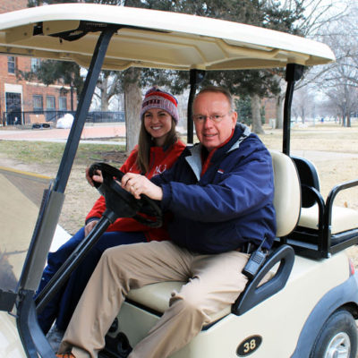 Mo Floyd and Adrienne Esposito sitting in the golf cart.