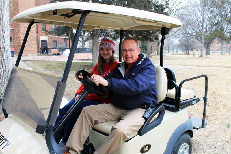 Mo Floyd and Adrienne Esposito sitting in the golf cart.