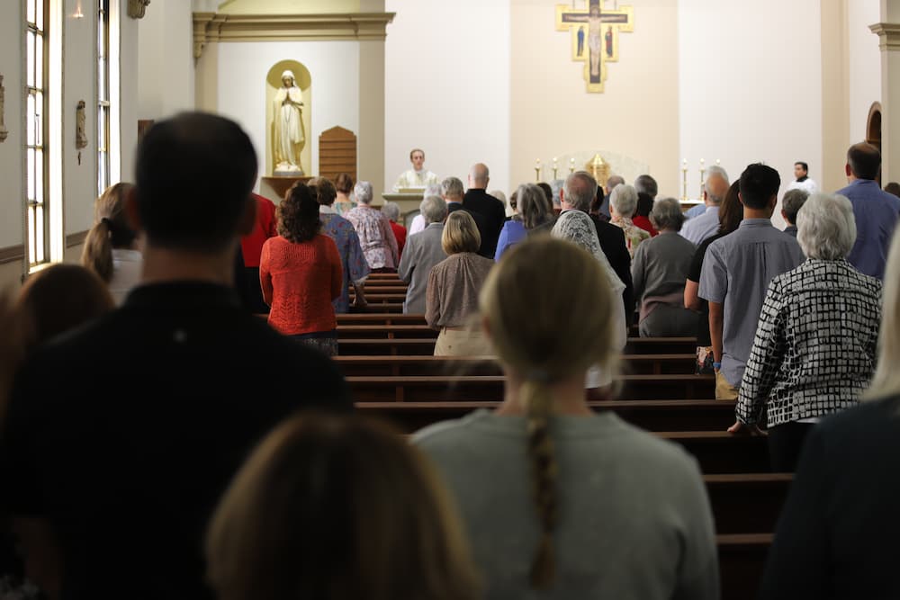 Newman community members fill St. John's Chapel to celebrate Sacred Heart Hall's 100th birthday.