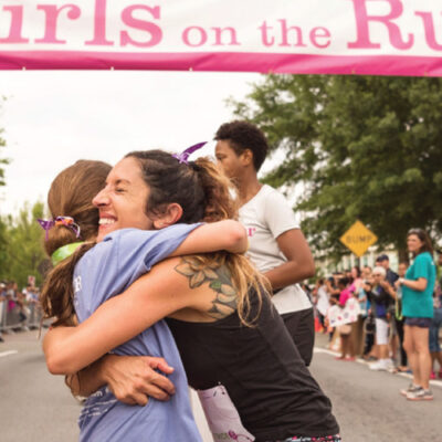 Christy Thomas embraces another runner at the finish line.