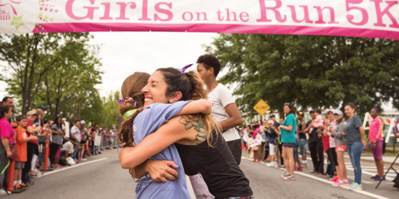 Christy Thomas embraces another runner at the finish line.