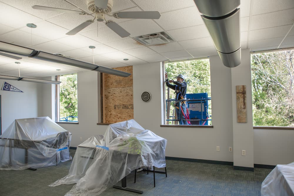 Construction workers replace the windows in Sacred Heart Hall.