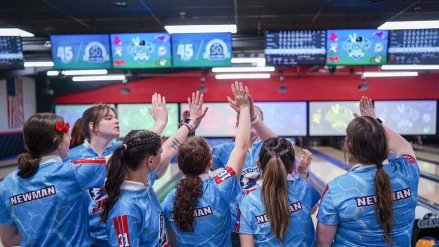 Newman women's bowling give high fives after achieving runners up status at the GLVC Championships.
