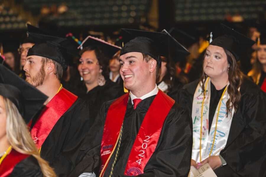 Dessenberger seated with fellow Newman University graduates of 2024.
