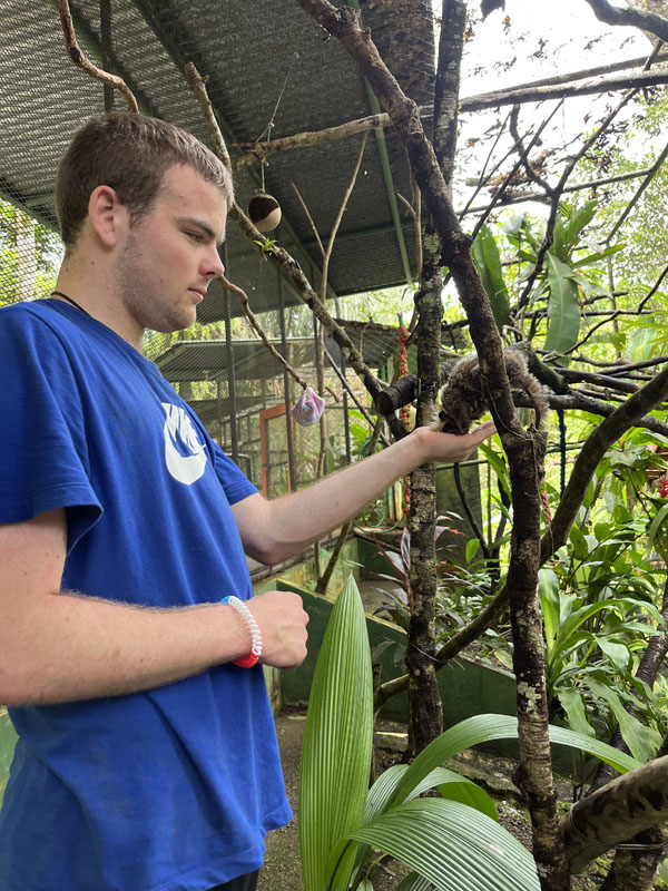 Joseph Luebbe feeding what appears to be a lemur.