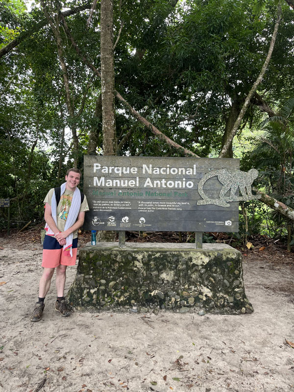 Joseph Luebbe standing in front of a Zoo entrance.